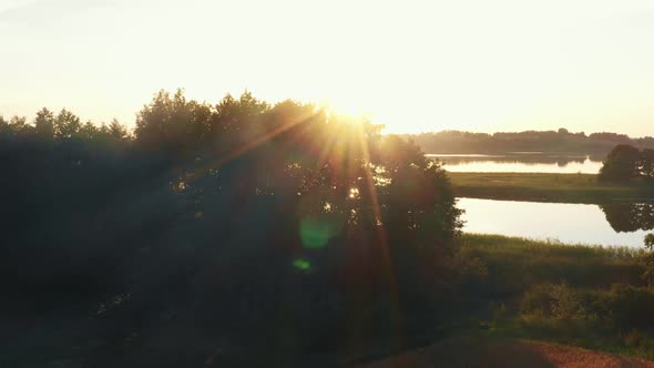 Drone Flyover Above Morning Camping Spot with Campfire Cars and Tents to Large Lake and Epic Summer