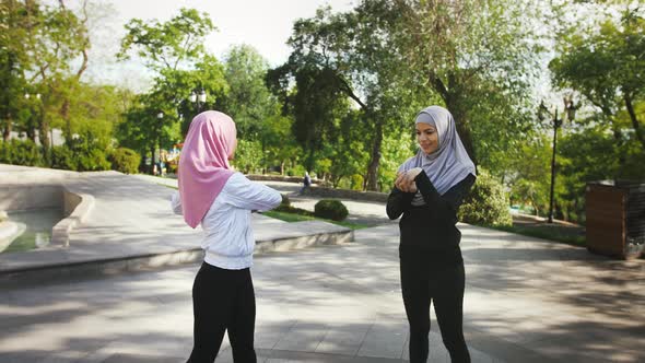 Two Darkskinned Muslim Girls in Sport Suits and Hijabs