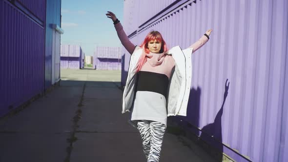 Happy Young Funky Woman with Pink Hair Dancing on Coloured Background