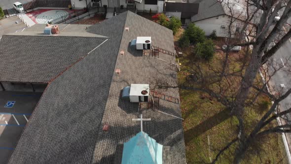 Aerial shot, flying over small town church steeple and building