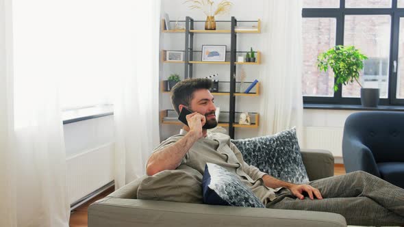 Happy Man Calling on Smartphone at Home