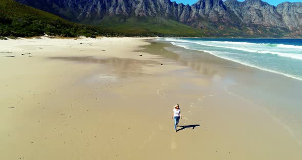 Aerial of woman walking on beautiful beach 4k