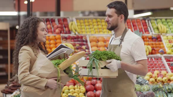 Salesman Communicating with Woman in the Market