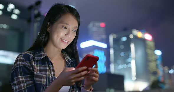 Woman use of mobile phone in city at night