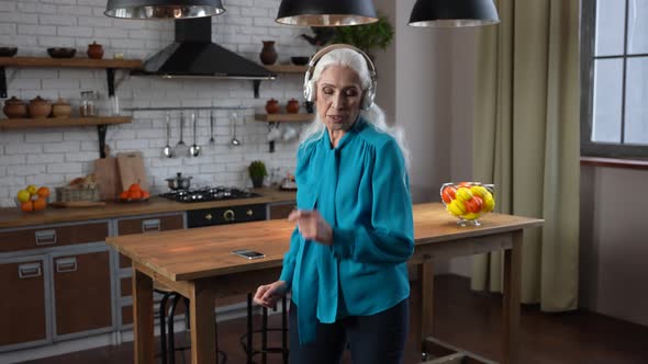 Happy Aged Female Enjoying Dance and Music Indoors