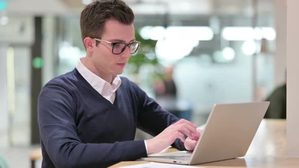 Young Businessman with Laptop Saying No with Finger Sign