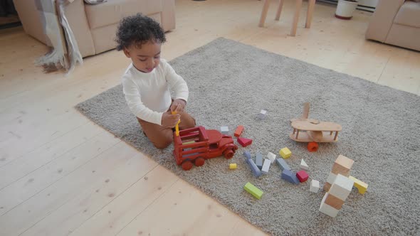 Cute Baby Boy Playing with Toys on Floor