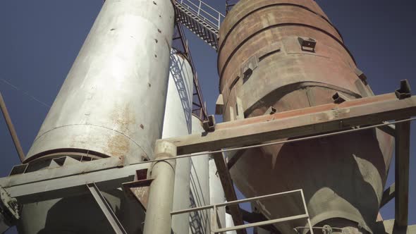 Huge Industrial Reservoir Towers at the Background of Clear Blue Sky Outdoors. Wide Shot of Cement