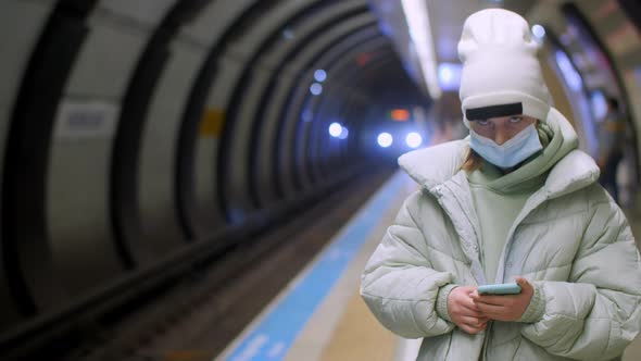Teenager Girl in Hat and Jacket Wearing Protective Face Mask on Subway Station