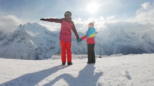 Mother and Daughter Enjoying Journey. Happy Family in Winter Clothing at the Ski Resort, Winter Time