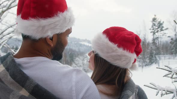 Two People Embracing in the Winter From the Hill with Santa's Hat Looking Into the Distance