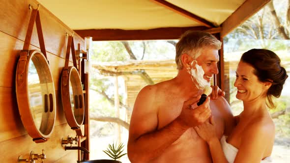 Smiling couple having fun while shaving in cottage 4k