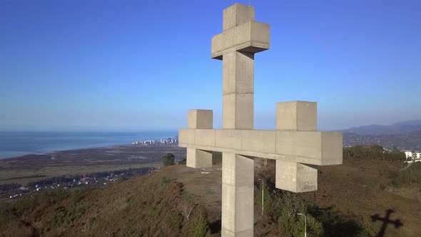 drone view flies around stone or concrete cross high in mountains