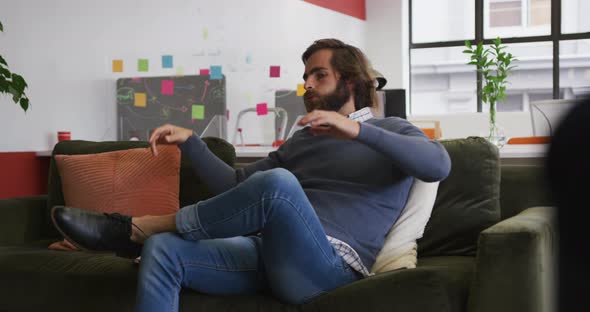 Caucasian businessman sitting on couch and resting in modern office