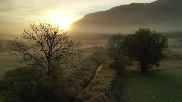 Flying over autumn landscape at sunrise