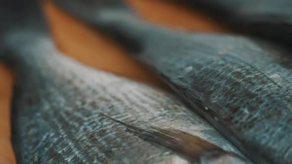 Fresh Raw Fish With Scaly Skin On A Wooden Cutting Board Ready To Be Descaled