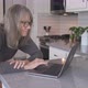 Senior white woman working online from home on laptop computer in kitchen - VideoHive Item for Sale