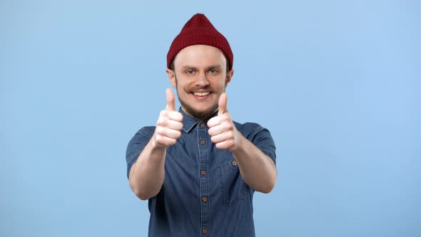 Portrait of Joyful Man with Curly Mustache and Hat Expressing Pleasure and Showing Thumbs Up