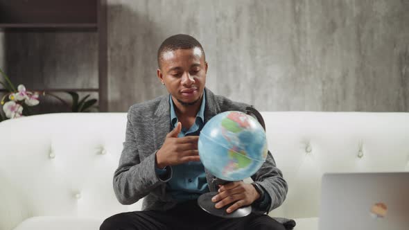 AfricanAmerican Geography Teacher Turns Globe on Couch