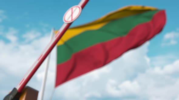 Closing Barrier with STOP CORONAVIRUS Sign at the Lithuanian Flag