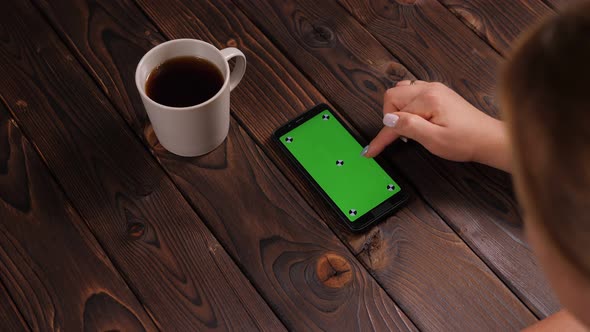 Closeup of a Woman Drinking Coffee and Using a Phone with a Green Screen