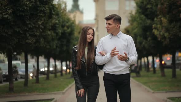 A Young Woman and a Man are Walking