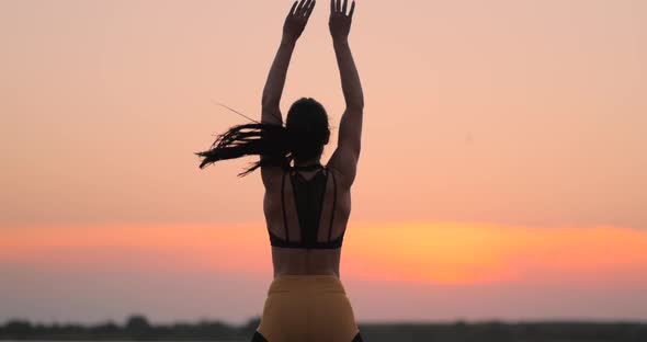 Happy Fitness Woman Doing Jumping Jacks or Star Jump Exercise at Seaside Outdoors Copy Space