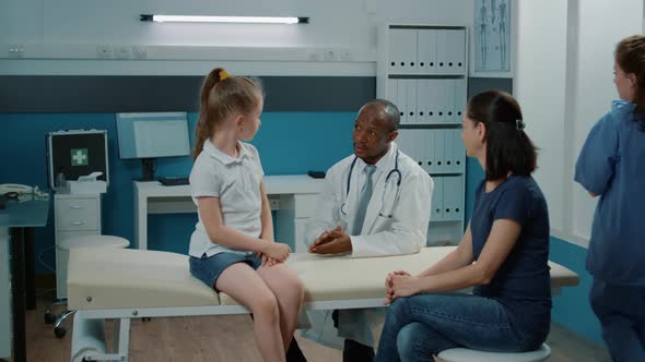 Friendly Doctor Giving Highfive to Cheerful Child at Checkup Visit