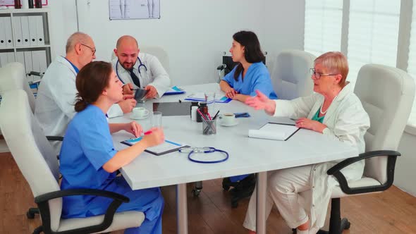 Medical Expert Talking with Medical Staff During Healthcare Meeting