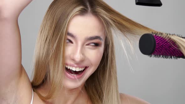 Happy Girl Drying Hair on the Brush