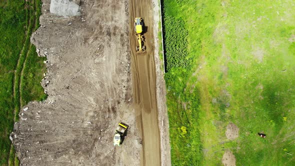 The process of building roads. The tractor aligns the ground.