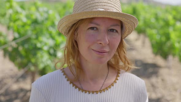 Headshot Confident Beautiful Caucasian Woman in Straw Hat Standing in Sunshine Outdoors Looking at