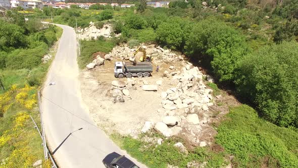 Excavator at Work with Loading of Stone Into Truck
