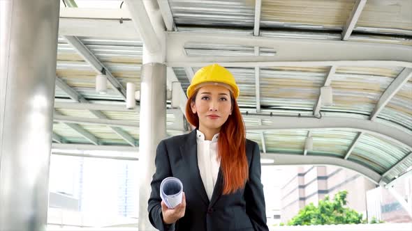 Young Attractive Asian Engineer in Business Suit with Safety Helmet Walking in Office Building