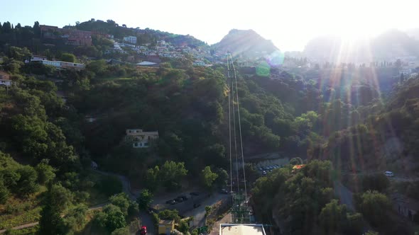 Bird's eye view on a long cable way leading to the top of the mountain. Taormina-Mazzaró route, Ital