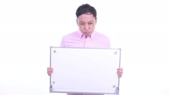 Stressed Japanese Businessman Holding White Board and Getting Bad News