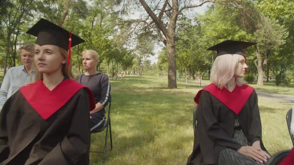 Happy Graduates in Academic Dresses Waiting for Graduation Ceremony