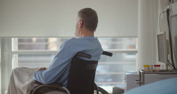 Portrait of Senior Man Sitting on Wheelchair in Rehabilitation Center