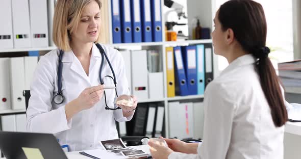 Doctor Showing Patient Silicone Implants for Breast Augmentation