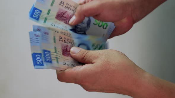 man or woman counting mexican bills of 500 pesos