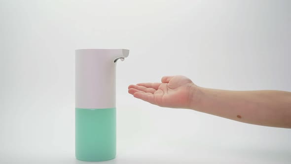 Automatic Soap Dispenser Uses a Small Child on an Isolated Background, Close-up of a Desk Hand and