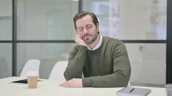 Sleepy Young Businessman Taking Nap While Sitting in Office