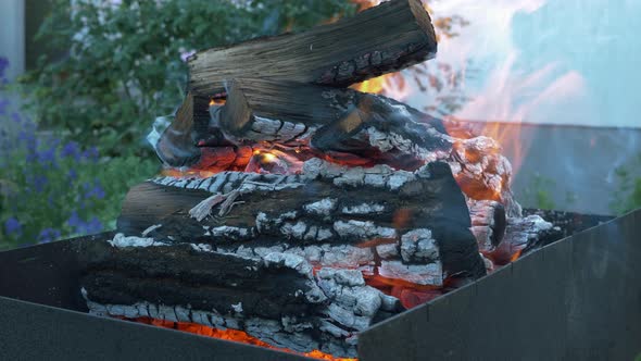 Make fire flames from firewoods for grill. Flaming backyard charcoal. Bonfire for grill or BBQ