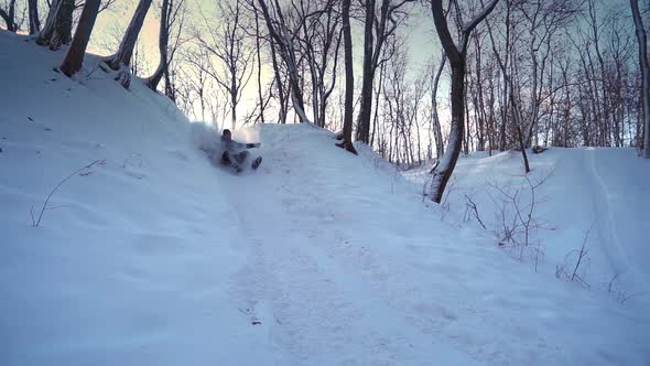 Happy Man Rides a Sled From a Snow Hill