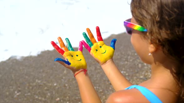 A Child at the Sea with Paints on Her Hands a Smile