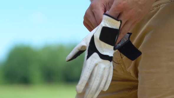 Man Putting on and Fixing on Hand Professional Leather Glove, Golf Game, Hobby