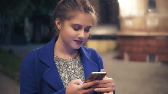 Young Attractive Woman Using Smart Phone at Night in City