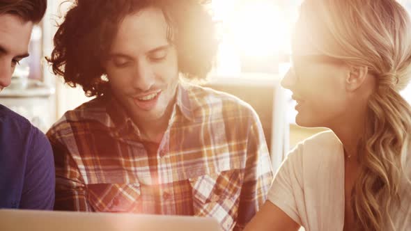 Friends using laptop while having a coffee