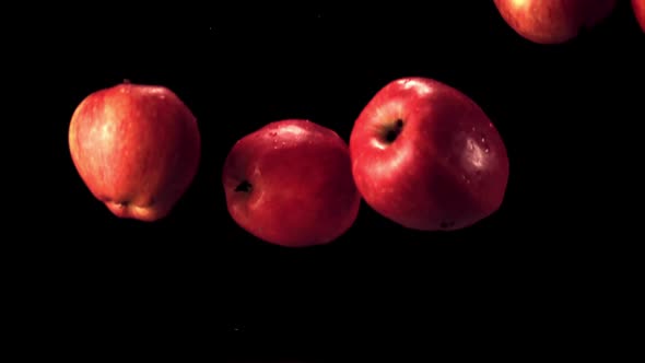 Super Slow Motion Red Apples Fall on the Water with Splashes