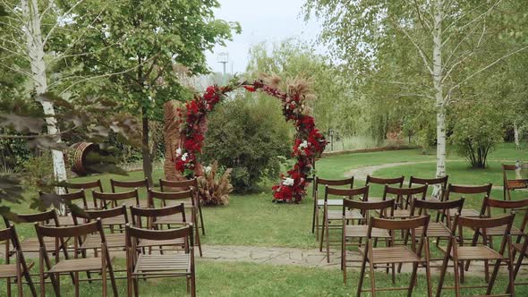 Red Arch and Wooden Chairs in the Park Slow Motion Shot